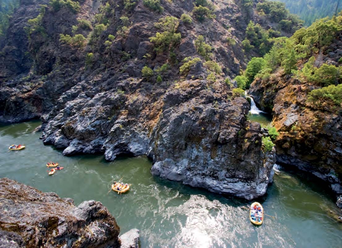 Rafts floating through a rocky canyon on the Rogue River
