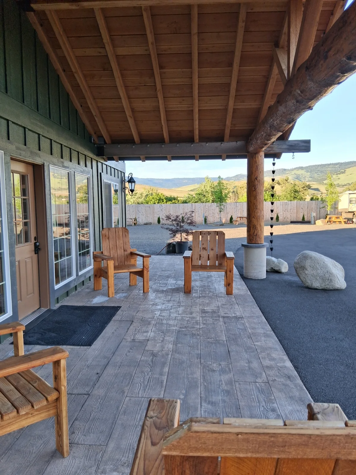 Covered lodge porch with wooden Adirondack chairs